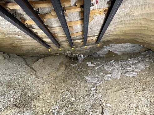 Der Blick geht in einen Hohlraum unter Tage. Schotter ist zu sehen, der bis unter die Decke der Kammer reicht. Salzbrocken haben sich zum Teil von der Decke gelöst und sind herabgefallen.