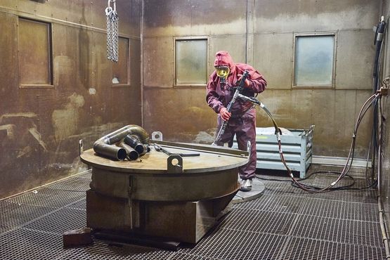 Ein Arbeiter beseitigt kontaminierte Rückstände mit einem Hochdruckwasserstrahl