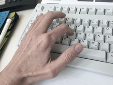 Eine Hand schreibt auf einer Computertastatur Eine Hand schreibt auf einer Computertastatur