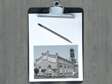 Clipboard with pencil and picture of the Asse 2 winding tower on a wooden board