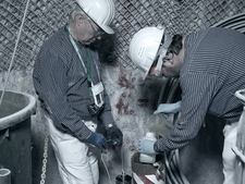 Two miners take a sample for further analysis
