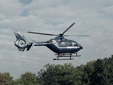 Ein Hubschrauber fliegt tief über ein Waldstück