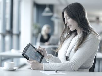 A woman, using a tablet. A woman, using a tablet.