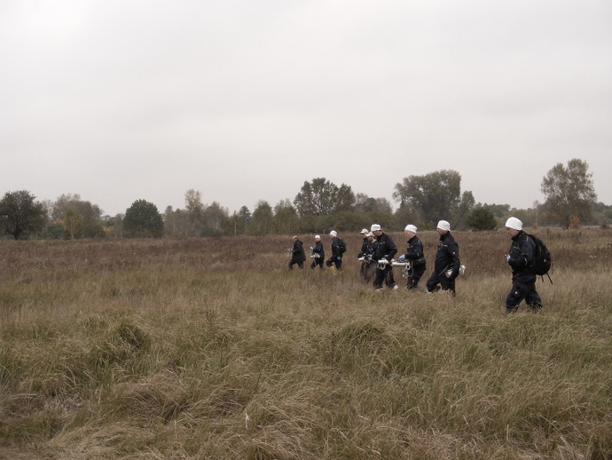 The group paces the field off with measuring instruments 