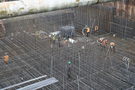 Bauleute montieren Bewehrungseisen in einer Baugrube auf der Schachtanlage Konrad 2