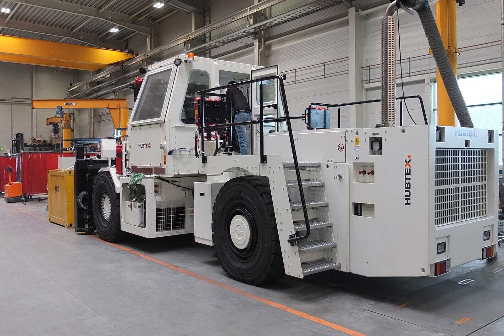 There is a large forklift in a hall.