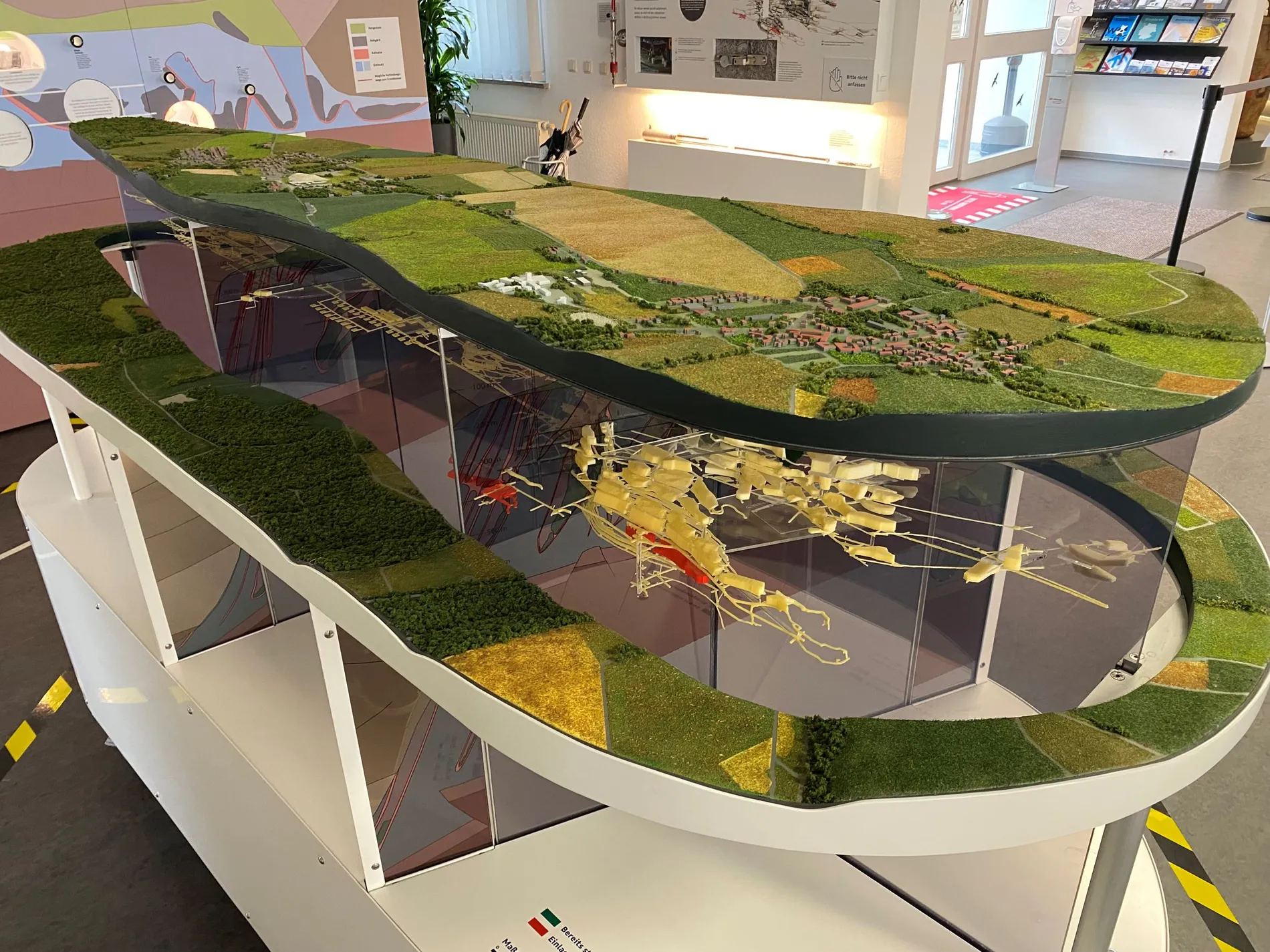 Auf einen Tisch ist ein Modell des Endlagers Konrad gebaut. Zu sehen ist die Eroberfläche sowie ein Modell der Schachtanlage unter Tage.