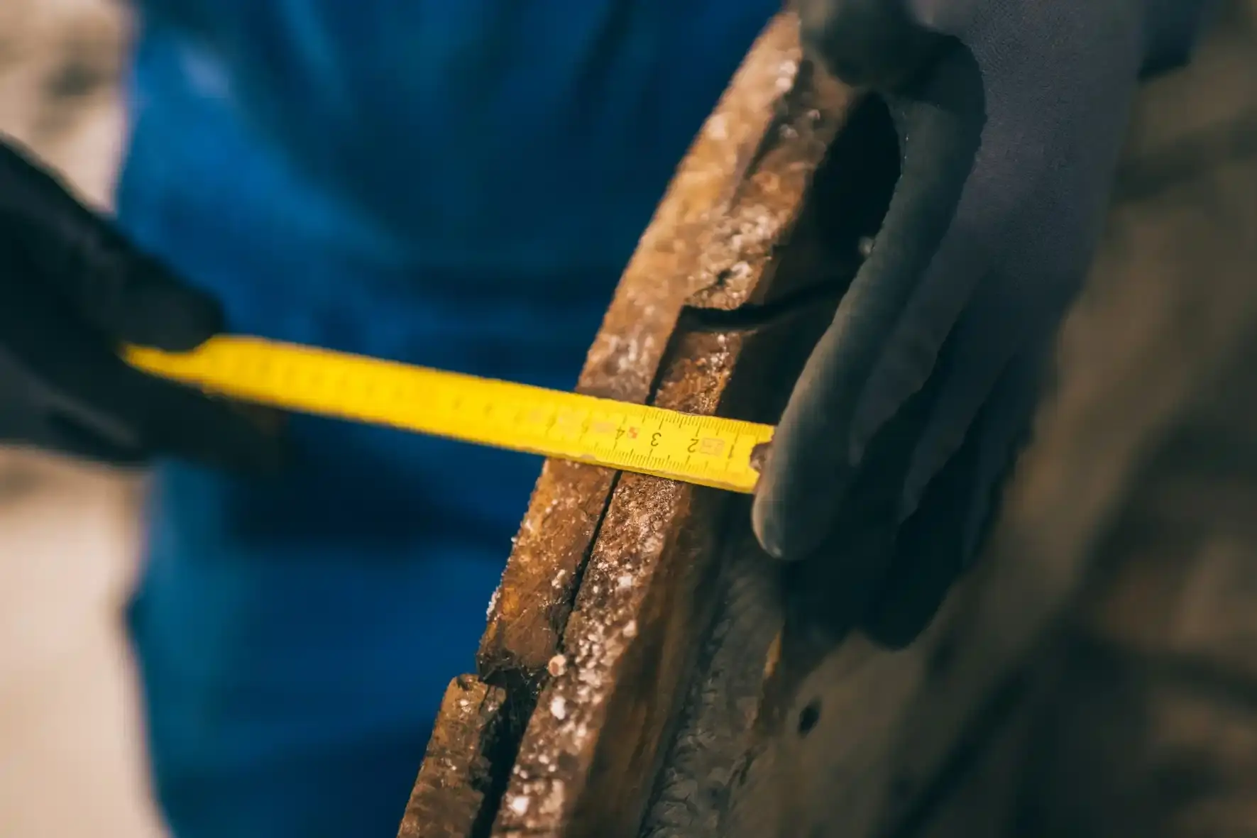 Nahaufnahme der Kabeltrommel, die mit einem gelben Gliedermaßstab vermessen wird.