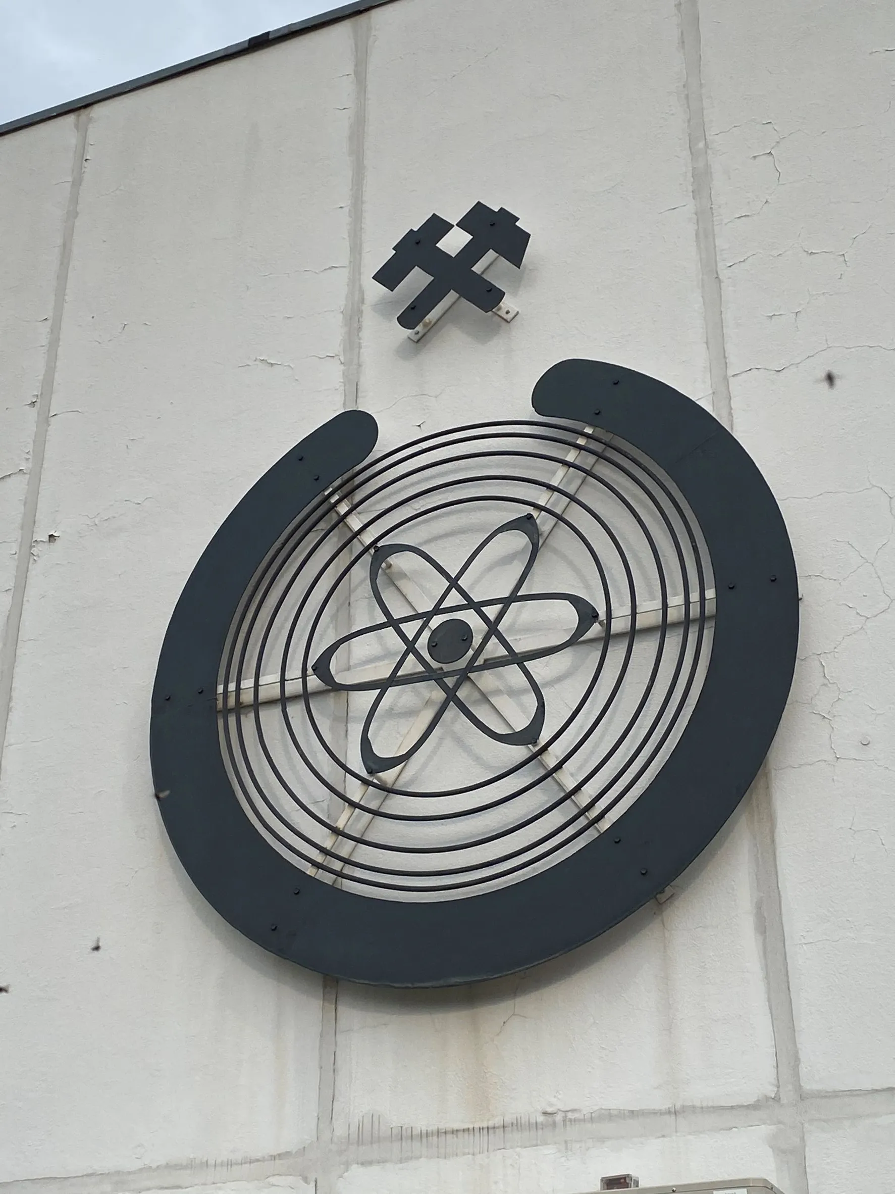 Ein rundes Symbol mit 2 gekreuzten Hammern hängt an einer Wand