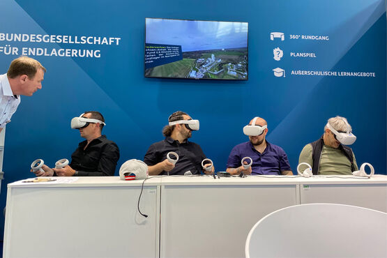 Vier Menschen mit VR-Brillen sitzen an einem Tisch