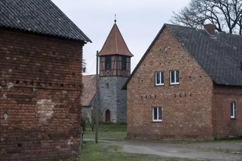 Foto des Ortskerns von Waddekath. Zu sehen sind zwei ältere Backsteingebäude, dazwischen ein Kirchturm.