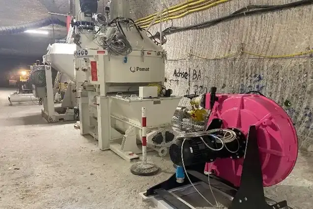 Foto einer weißen Industrieanlage unter Tage in einem Salzbergwerk. Ein Teil der Anlage ist rosa und an den Wänden verlaufen gelbe und schwarze Kabel.