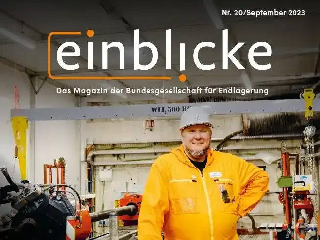 Titelseite des Einblicke-Magazins Nummer 20. Darauf zu sehen: Ein Bergmann in Arbeitskleidung und mit Schutzhelm neben einer großen Maschine. Daneben der Titel: "Wie sieht's aus? Über die Erkundung der Einlagerungskammern"