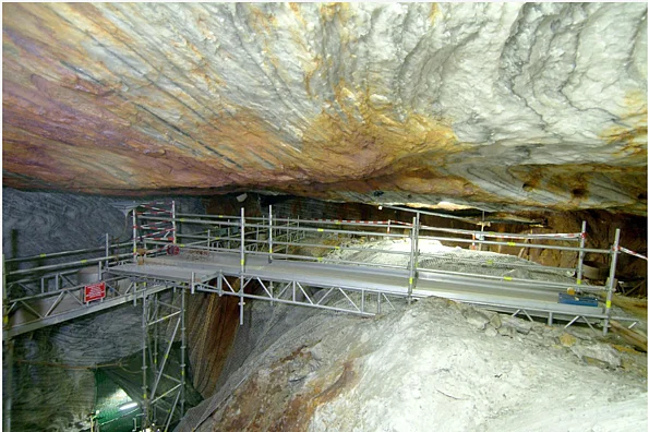 Das Foto zeigt einen Hohlraum in einem Bergwerk. Ein Baugerüst macht die verschiedenen Ebenen zugänglich. 