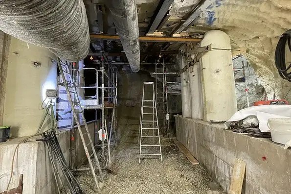 Foto eines Baustellenbereichs mit Leitern, Metallgerüsten und Stützbauwerken, die bis zur Decke reichen.