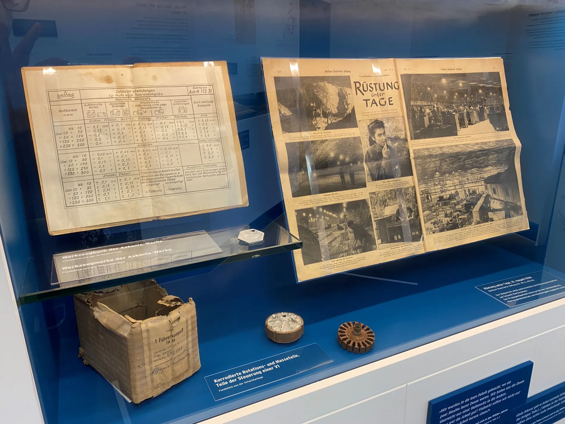 Ein Buchdokument und ein Bilddokument in einer Ausstellungsvitrine.