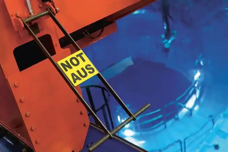 Not-Aus-Hebel an einer Metallkonstruktion über einem blauen Wasserbecken, in einer Anlage.