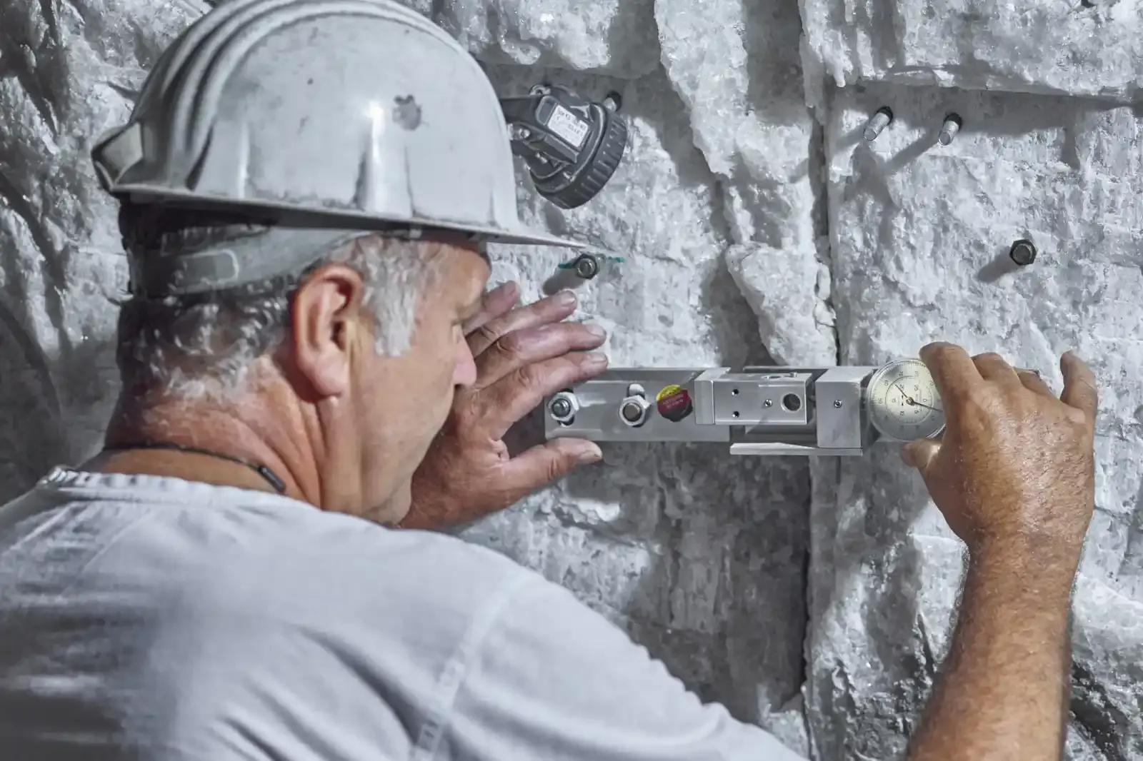 An employee at the Asse II mine uses a fissurometer to check a crack in the mine. The mine workings are heavily stressed by the sustained rock pressure.