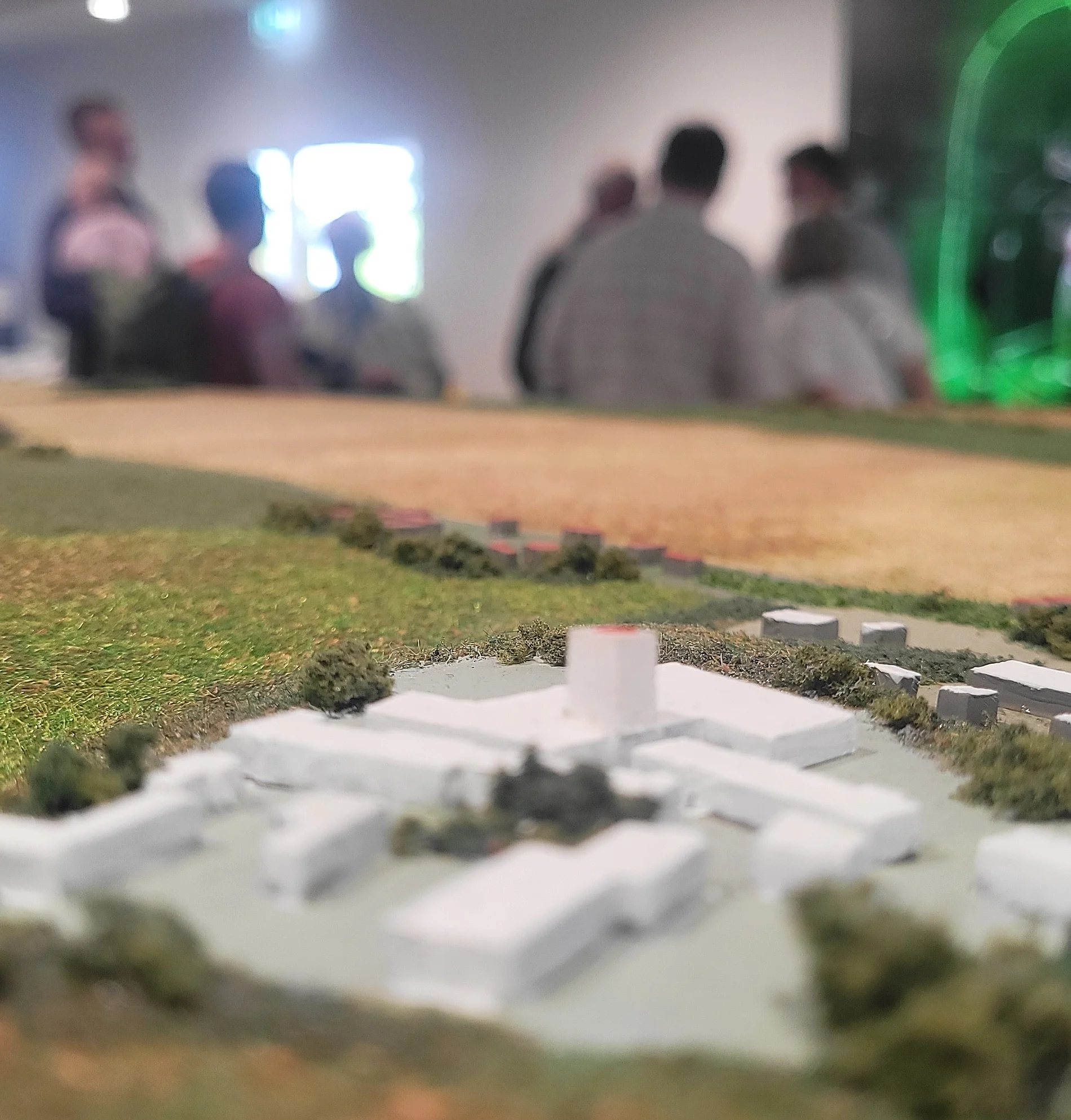 Mehrere Personen schauen sich Ausstellungsobjekte in einem Raum an. 