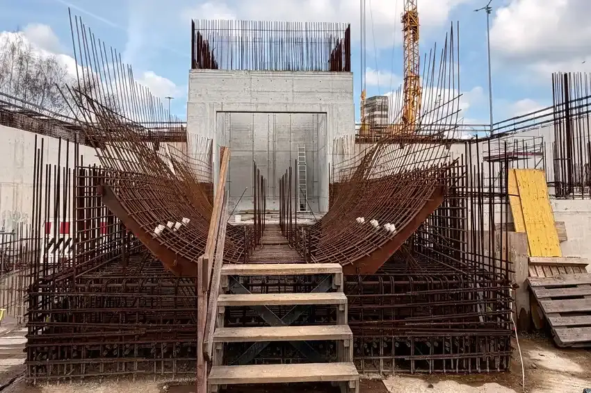 Das Foto zeigt eine Baustelle mit Drahtkonstruktionen und einer Holzleiter.