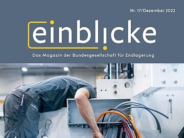 Das Cover des Einblicke Magazins 17 zeigt einen Mechaniker, der an einer Maschine arbeitet. Sein Kopf verschwindet dabei im Rumpf der Maschine, im Vordergrund befinden sich dicke Kabel.