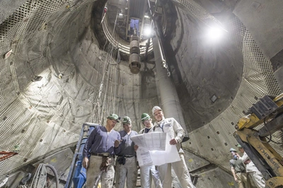 Bergleute im Bergwerk Konrad betrachten einen Plan