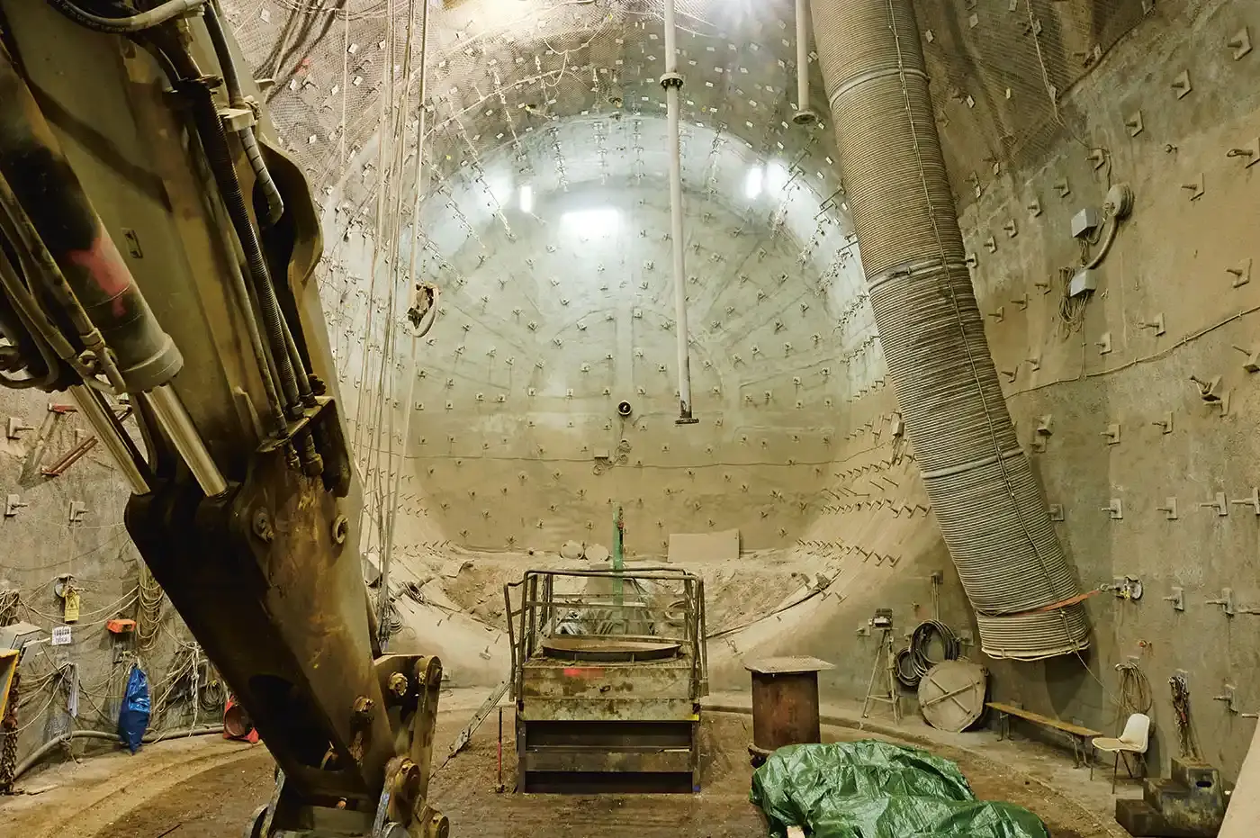 Blick in einen großen unterirdischen Kuppelraum mit Baugeräten, Schläuchen und Beleuchtung: Arbeiten in 850 Metern Tiefe.