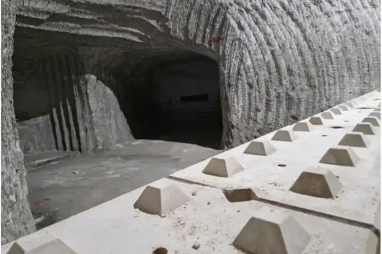 Das Bild zeigt einen von einer Mauer abgetrennten Bereich im Bergwerk. Die Mauer besteht aus mehreren großen grauen Betonsteinen. An den Wänden des abgetrennten Bereiches sind typische Frässpuren zu erkennen.