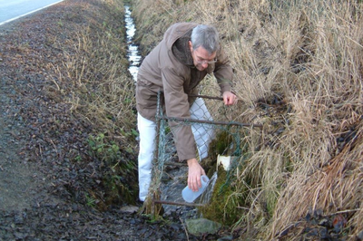 Ein Mann fängt mit einem Behälter Wasser auf. 