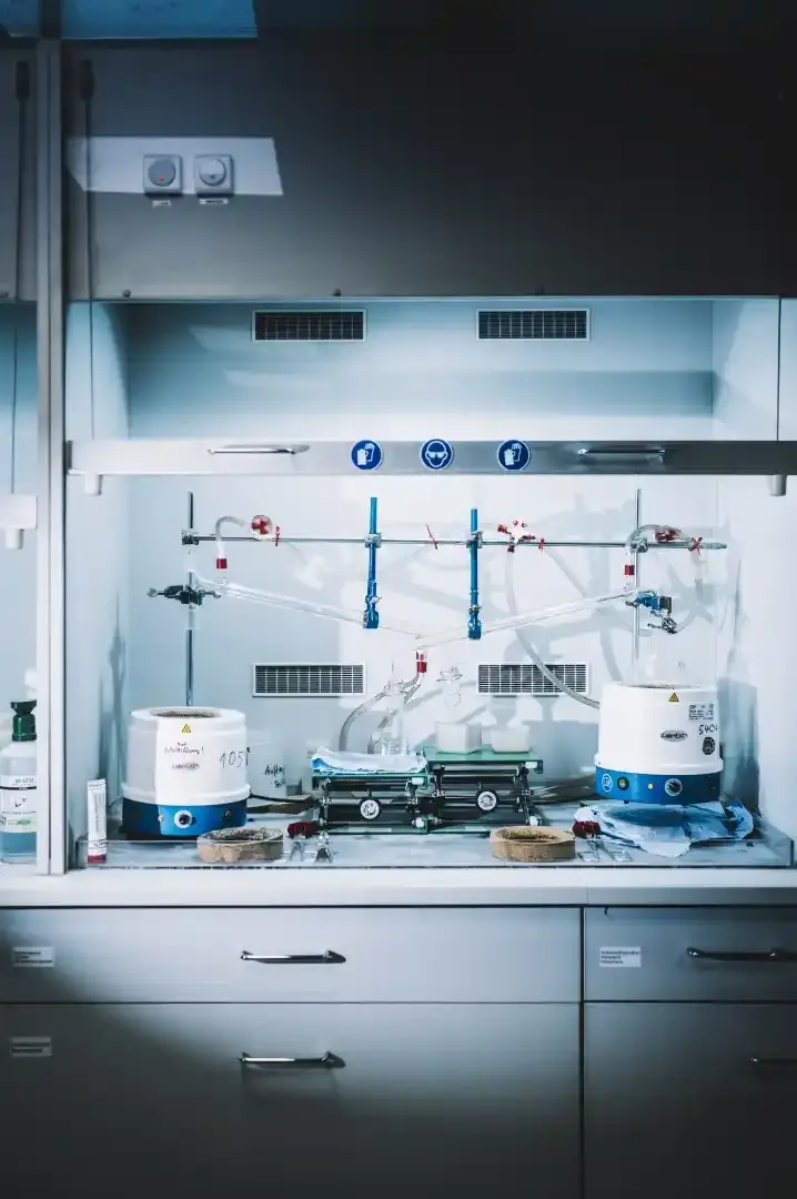 Arbeitsplatz im Labor, auf dem mehrere Messgeräte stehen. Unterhalb der Arbeitsplatte befinden sich Schränke.