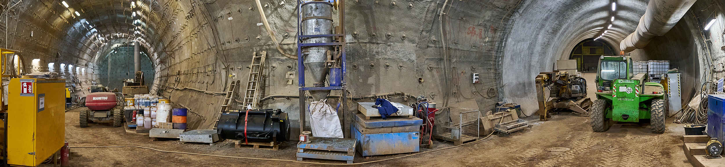Das Foto aus dem Endlager Konrad zeigt einen untertägigen Bereich mit Baustellenfahrzeugen, Maschinen und Behältnissen.