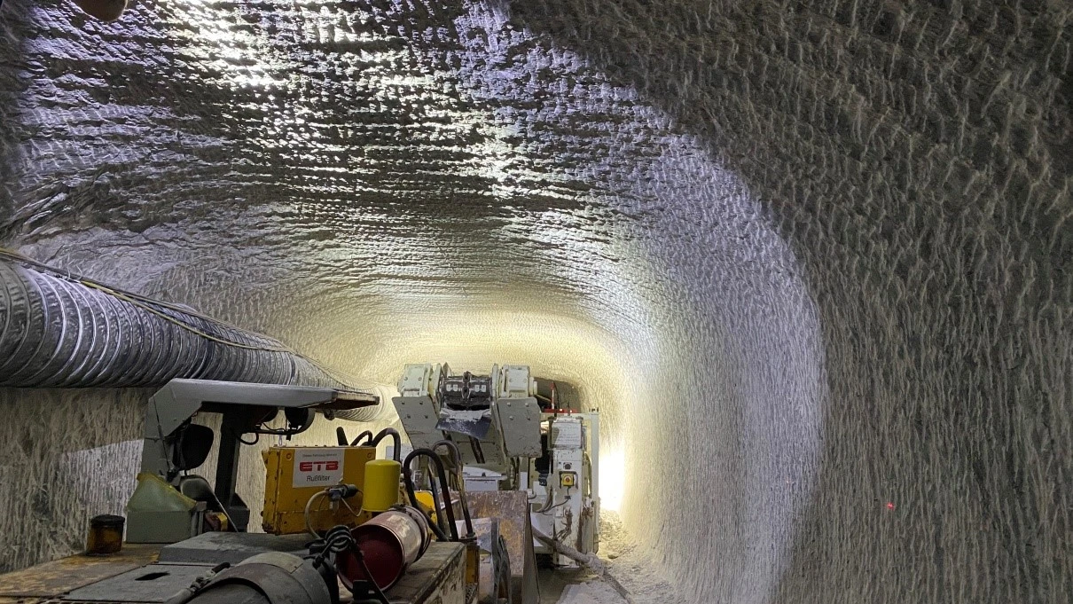 Teilschnittmaschine unter Tage Eine große Maschine auf einem Kettenfahrwerk steht in einem Streckenabschnitt im Bergwerk Morsleben und fräst mit ihrem Schneidkopf Gestein aus der Kontur