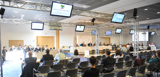 Personen sitzen auf Stühlen in einem Konferenzraum. Zur Seite "Stilllegung des Endlagers Morsleben"