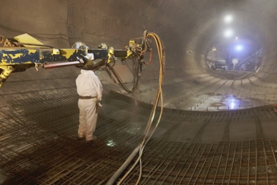 Ein Arbeiter spritzt mit einer Maschine Beton auf eine vorbereitete Fläche im Endlager Konrad unter Tage