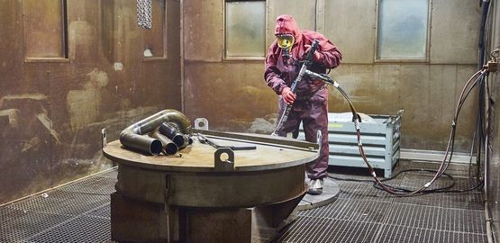 Ein Arbeiter beseitigt kontaminierte Rückstände mit einem Hochdruckwasserstrahl