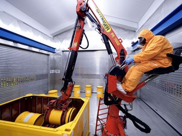 Ein Arbeiter bestückt im Zwischenlager Karlsruhe einen Transportcontainer mit Abfallbehältern