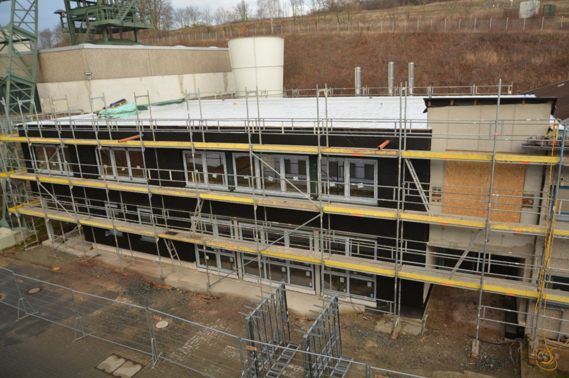 Zwischen Schachthalle (links) und Kauengebäude (rechts) wird ein neuer Zwischentrakt gebaut. Nach Fertigstellung werden hier die Grubenwehr, die Dosimetrie sowie die Lampenstube Platz finden.