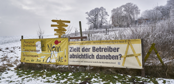 Eine Schneelandschaft mit zwei großen Plakaten der Bürgerinitiativen. Zur Seite "Akteure und Aufgaben"