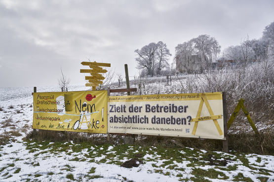 Eine Schneelandschaft mit zwei großen Plakaten der Bürgerinitiativen.