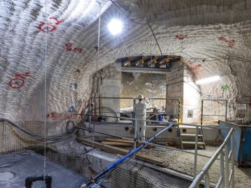 Ein hell erleuchteter Hohlraum unter Tage: Links im Bild befindet sich ein Speicherbecken; es ist umrandet von einem Metallgeländer. Im Hintergrund ist ein Bergmann in weißer Arbeitskleidung zu sehen.