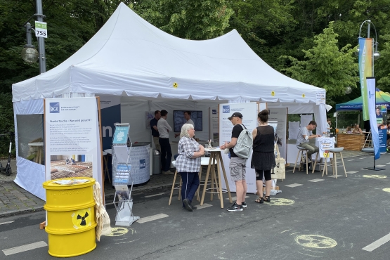 Zu sehen ist der Messestand der BGE mit mehreren Besuchern, welche sich im Dialog befinden, oder die Infoaufsteller lesen.