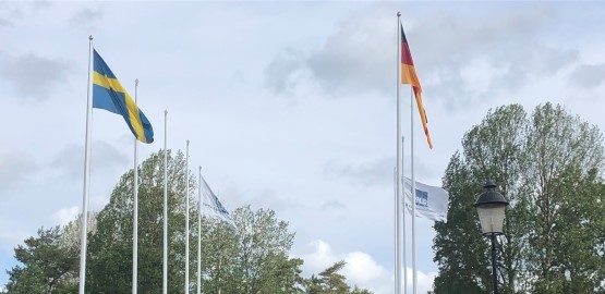 Flagpoles with the Swedish and German flags. Link to page "International collaboration"
