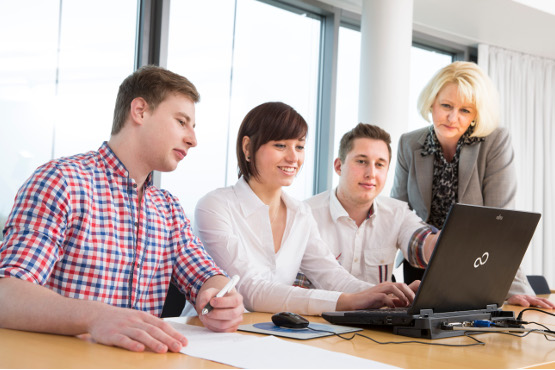 Trainees office management clerks work in a team on a project.