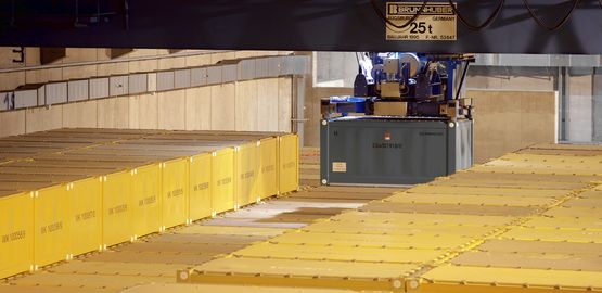 Ein Container hängt an einem Kran. Zur Seite "Aktueller Bestand"