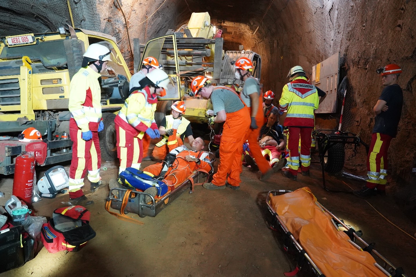 Mehrere Personen des Rettungsdiensts unter Tage, ein Arbeiter auf einer Trage