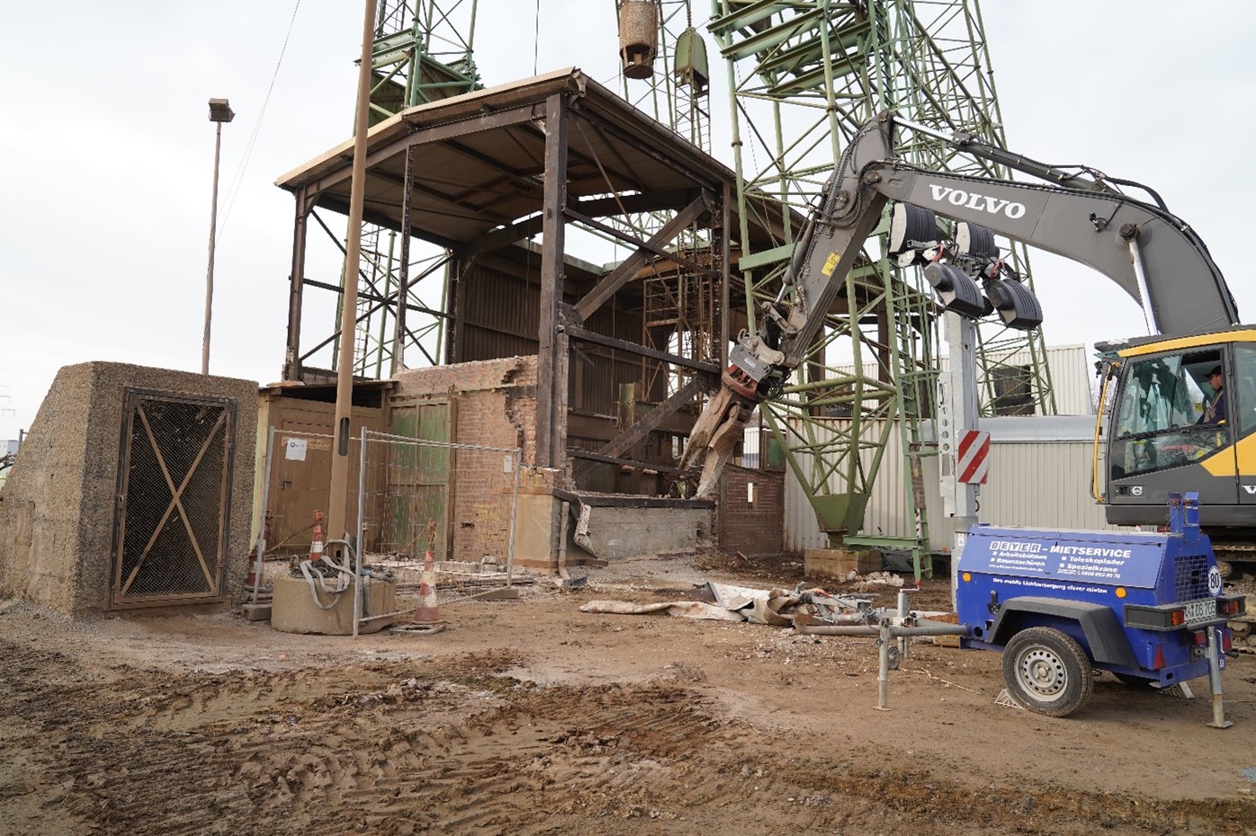 Bagger mit Kneifzange reißt eine alte Halle ein