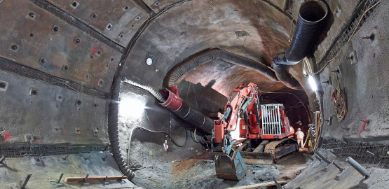 Ein Bagger trägt Gestein in einer Strecke ab. Link zur Seite "Wann wird Konrad fertig?"