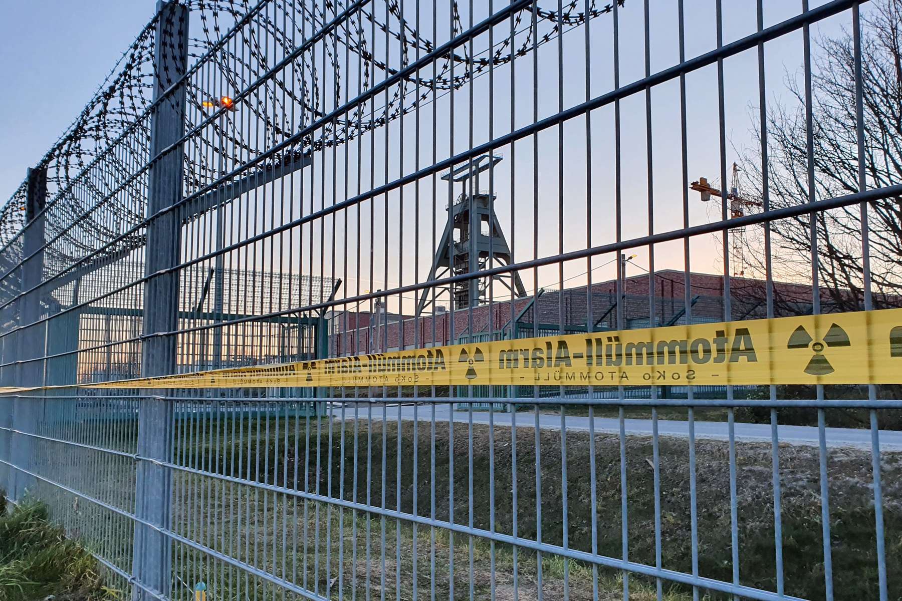 Ein schwerer Eisenzaun vor dem Endlager Konrad mit Symbolen des Widerstands gegen die Anlage