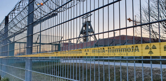 Ein schwerer Eisenzaun vor dem Endlager Konrad mit Symbolen des Widerstands gegen die Anlage. Link zur Seite "Wie sieht es mit der Akzeptanz des Standortes aus?"