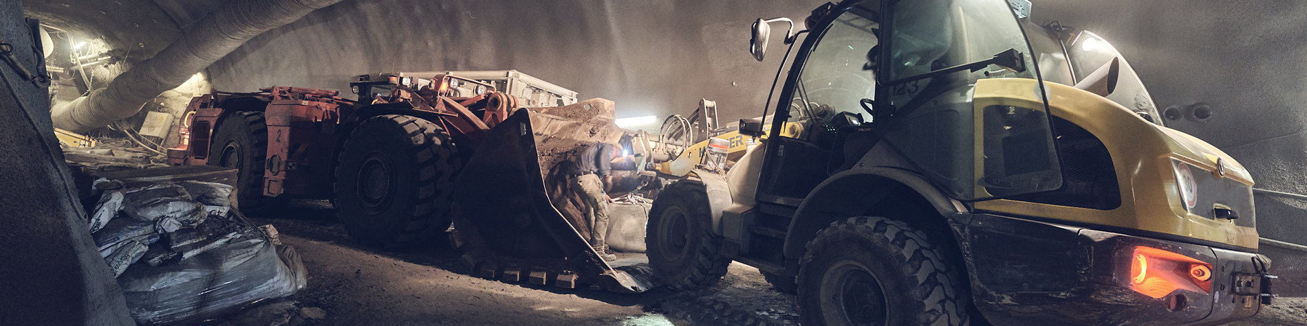 Zwei Radlader verladen Baumaterial unter Tage im Bergwerk Konrad